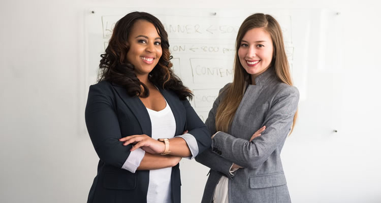 Picture of two business women posing for a photograph.