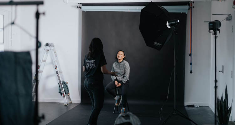 A woman in a photography studio getting her photo taken.