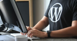 A web designer using WordPress on a desktop computer.
